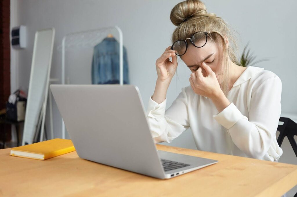 femme fatiguée sur son bureau devant son ordinateur